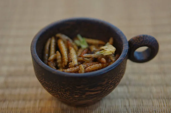 Edible Insects Bamboo Caterpillars in cup on a bamboo place mat