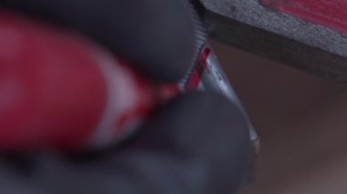 Dairesel testere ile kesmek için metal bir kirişe iz bırakan bir adamın görüntüleri.