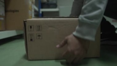 Ağır çekim: Paket personeli kargo kutusunu rafa kaldırdı