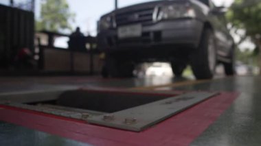 Araba servisindeki görüntüler, gümüş arabanın tekerleklerini kontrol etmek. 