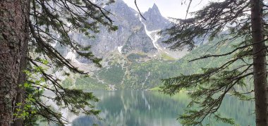 Orta Avrupa 'nın dağlarındaki turkuaz kayalıklar arasındaki dağ gölü