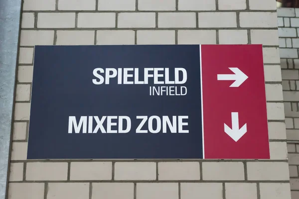 スタジアム内野と英語とドイツ語のミックス ゾーンの方向を示す記号 — ストック写真