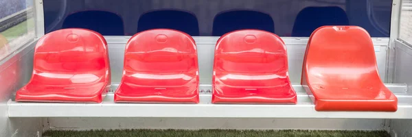 Detail of red Reserve chair and staff coach bench in sport stadium