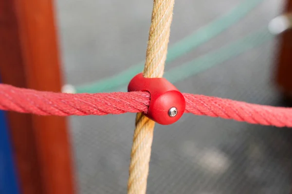 Different colored ropes with plastic fastenings on the playground