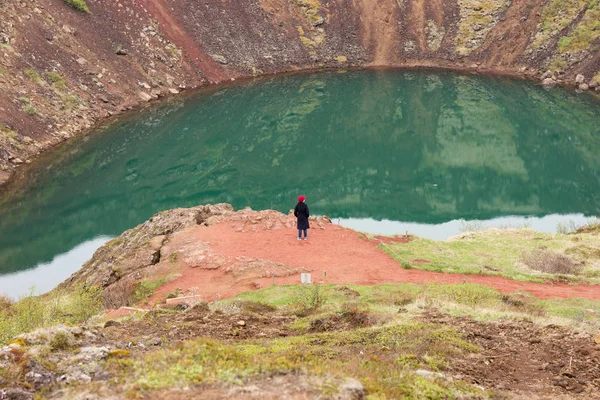 Woman on the precipice of the volcano crater in Iceland