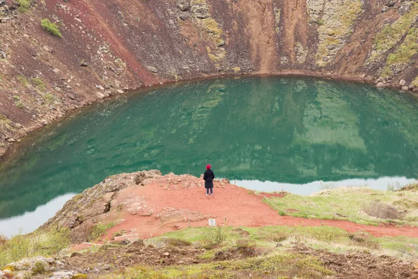 Woman on the precipice of the volcano crater in Iceland