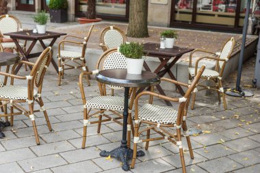 Sokak cafe misafirler için bekliyor. Boş sandalye ve masa yaz aylarında