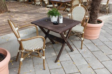 Sokak cafe misafirler için bekliyor. Boş sandalye ve masa yaz aylarında