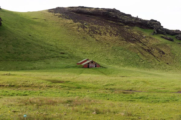 在冰岛的山脉前的老废弃的房子 — 图库照片
