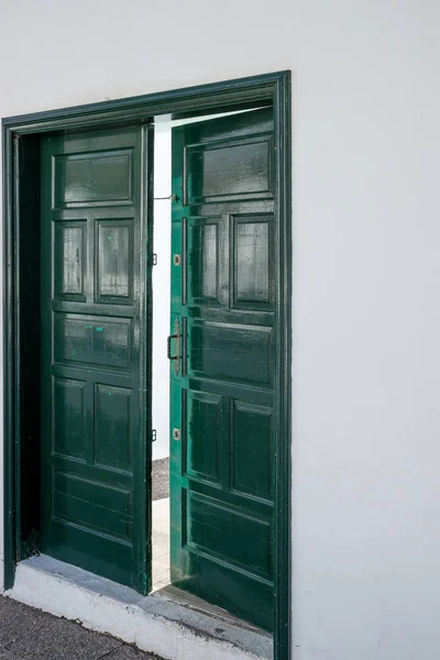 Green wooden open door. Entrance door opened a crack