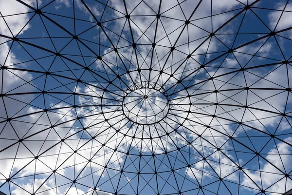 Mavi gökyüzü ve bulutlar içinde belgili tanımlık geçmiş bir demir yapısının alt görünümü