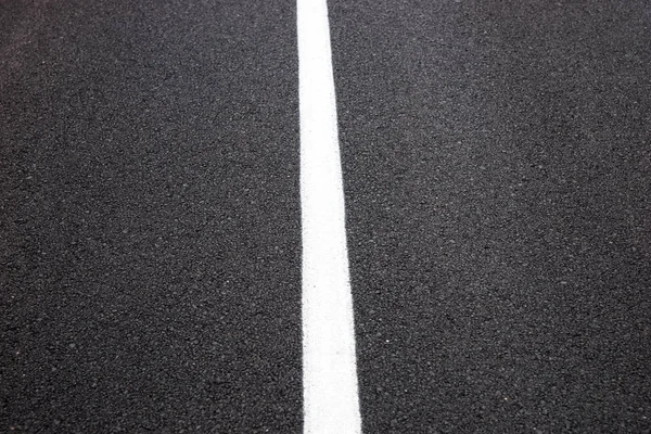 Asphalt road center white line on freeway or highway texture background