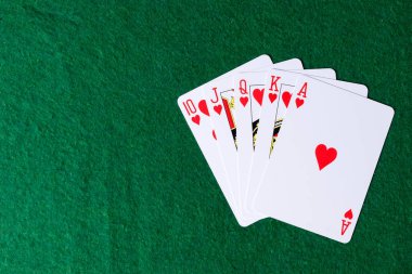 Yeşil arka planda kalplerin Kraliyet floş. Poker iskambil kağıtları kazanan eller
