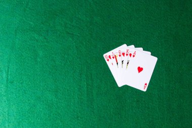 Yeşil arka planda kalplerin Kraliyet floş. Poker iskambil kağıtları kazanan eller