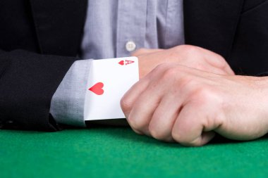 Siyah takım elbisenin kolunda kalplerin kart as