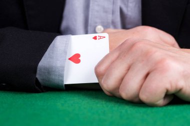 Siyah takım elbisenin kolunda kalplerin kart as