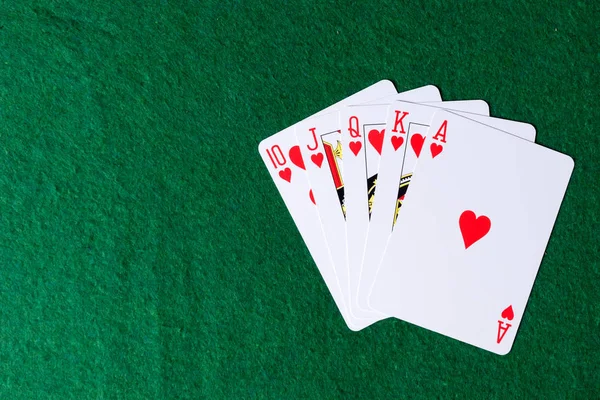 Royal flush of hearts on green background. Winning hands of poker playing cards