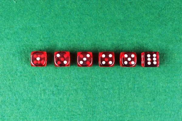在绿色背景上 一排红色骰子从一到六个 — 图库照片