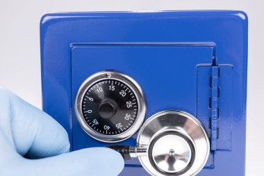 Mavi kasanın kilidini açarken bir hırsızın elinin steteskopla kapatılması