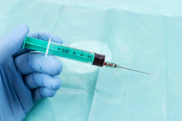 Mão Médico Masculino Segurando Uma Seringa Com Sangue Fundo Verde — Fotografia de Stock