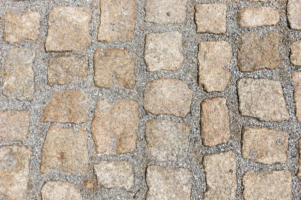 Old stone pavement texture. Granite cobblestones pavement background. Abstract background of old cobblestone