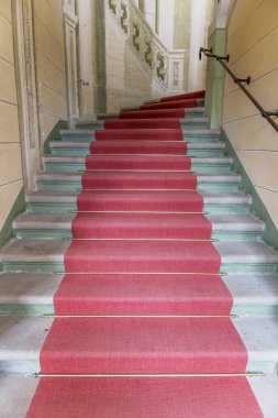 Binanın merdivenlerinde kırmızı halı yukarı bakıyor
