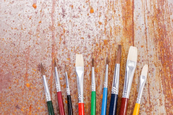 Fila Pinceles Colores Encuentran Mezclados Sobre Fondo Oxidado — Foto de Stock