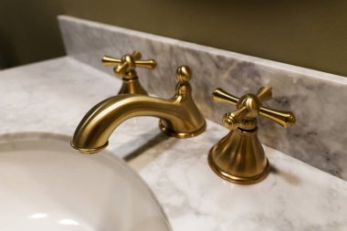 Pahalı mermer taştan yapılmış lavabo. Musluk ve muslukların altın tasarımı