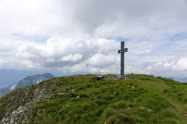 Avusturya Alpleri 'ndeki Ölü Dağlar' daki Ezik Tepesi 'nin (Totes Gebirge) tepesindeki büyük haçın manzarası