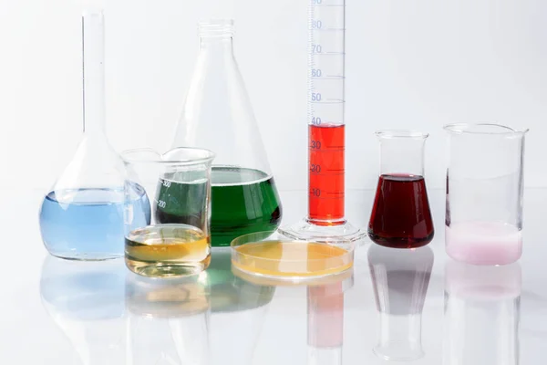 Szklana Aparatura Laboratoryjna Wodą Kolorową Szklanym Stole — Zdjęcie stockowe