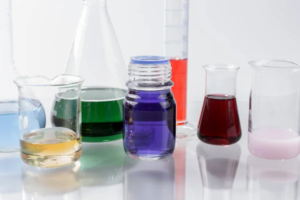 Laborgerät Aus Glas Mit Farbigem Wasser Auf Dem Glastisch — Stockfoto