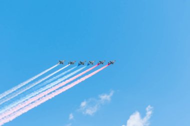 Bir grup uçak gökyüzünde renkli dumanla Rus bayrağı yapıyor, kırmızı, mavi ve beyaz. 