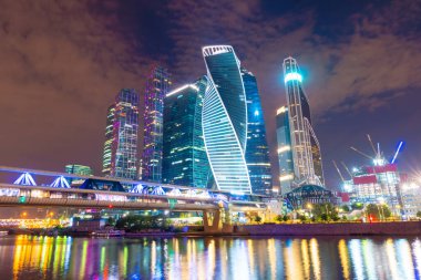 Moskva nehrinin yüzeyine yansıyan renkli ışıklarla gece Moskova gökyüzü manzarası. Rusya 'da iş ve yaşam tarzı için modern gökdelenler.