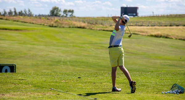 Vuruştan sonra son pozisyonda golf oynayan bir adam