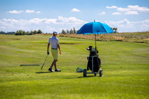 高尔夫球场上的人准备好要玩醒目的高尔夫球车和蓝天绿草 — 图库照片