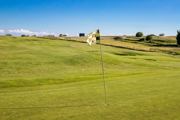 在高尔夫球场上有格子的旗帜 表示球洞的意思 — 图库照片#