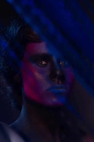 Glowing neon makeup with dramatic look in his eyes. Stock Photo by  ©korabkova 120650012