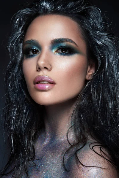 Sköna flicka med blått glitter i ansiktet — Stockfoto