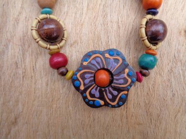 Kahverengi arka planı olan tahta bir kolye. Ahşap arka plandaki kolye..