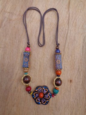 Kahverengi arka planı olan tahta bir kolye. Ahşap arka plandaki kolye..