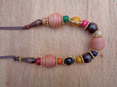 Kahverengi arka planı olan tahta bir kolye. Ahşap arka plandaki kolye..