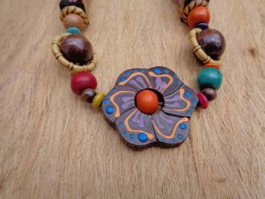 Kahverengi arka planı olan tahta bir kolye. Ahşap arka plandaki kolye..