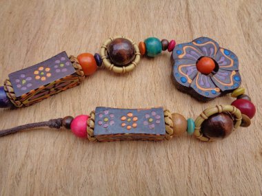 Kahverengi arka planı olan tahta bir kolye. Ahşap arka plandaki kolye..