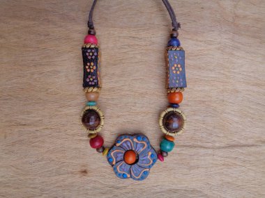 Kahverengi arka planı olan tahta bir kolye. Ahşap arka plandaki kolye..