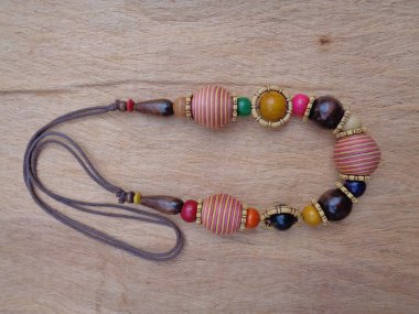 Kahverengi arka planı olan tahta bir kolye. Ahşap arka plandaki kolye..