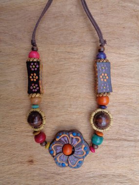 Kahverengi arka planı olan tahta bir kolye. Ahşap arka plandaki kolye..