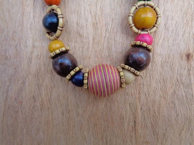 Kahverengi arka planı olan tahta bir kolye. Ahşap arka plandaki kolye..