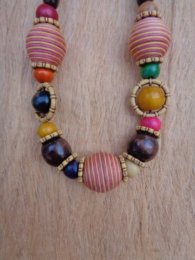 Kahverengi arka planı olan tahta bir kolye. Ahşap arka plandaki kolye..