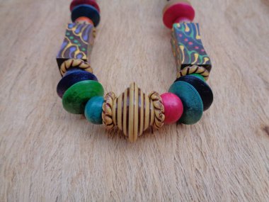 Kahverengi arka planı olan tahta bir kolye. Ahşap arka plandaki kolye..