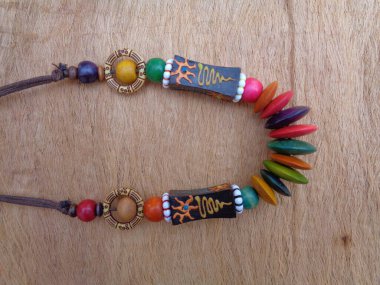 Kahverengi arka planı olan tahta bir kolye. Ahşap arka plandaki kolye..